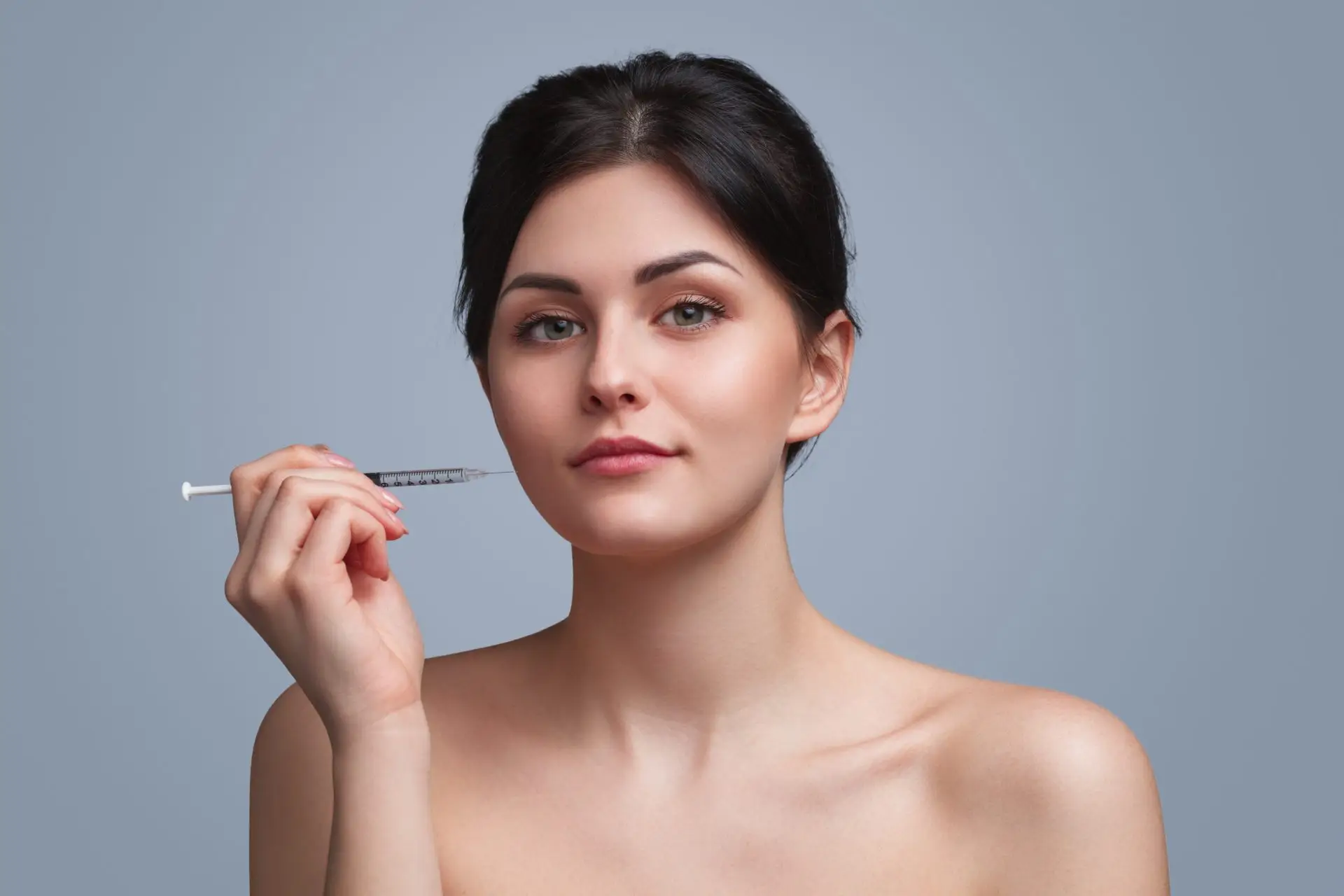 young-woman-with-cosmetic-syringe-looking-at-camer-2023-11-27-04-58-19-utc